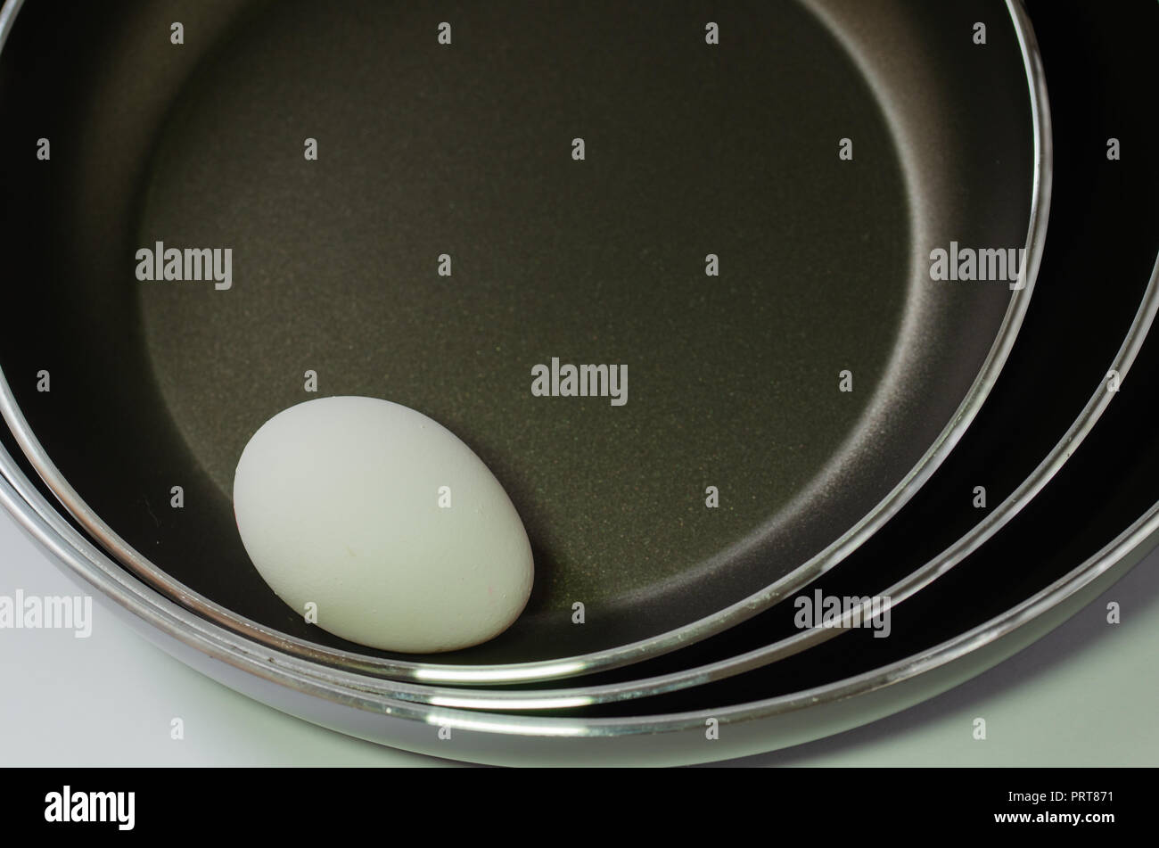 One egg in three pans,black background Stock Photo Alamy