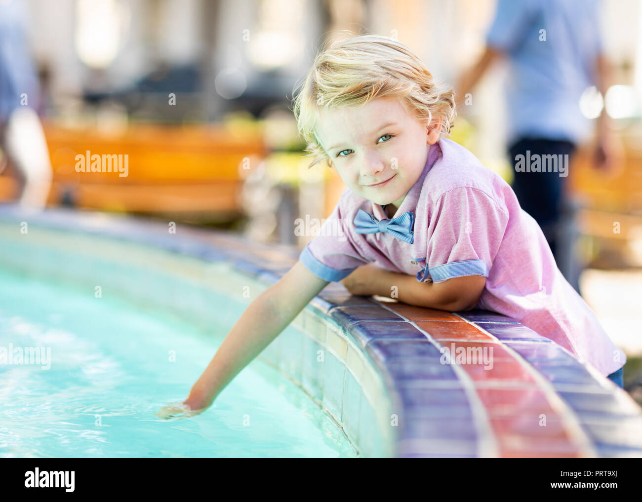 Cute Young Caucasian Boy Enjoying The Fountain At The Park. Stock Photo
