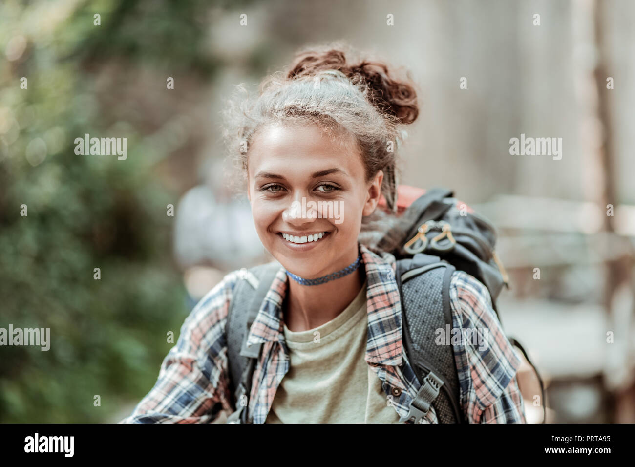 Close up of beaming smiling female backpacker enjoying her day greatly Stock Photo