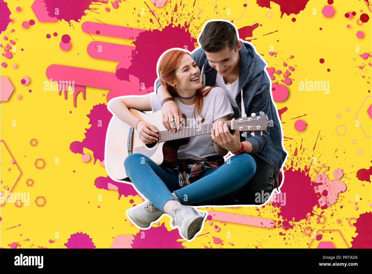 Happy red haired girl playing the guitar with her boyfriend and smiling Stock Photo