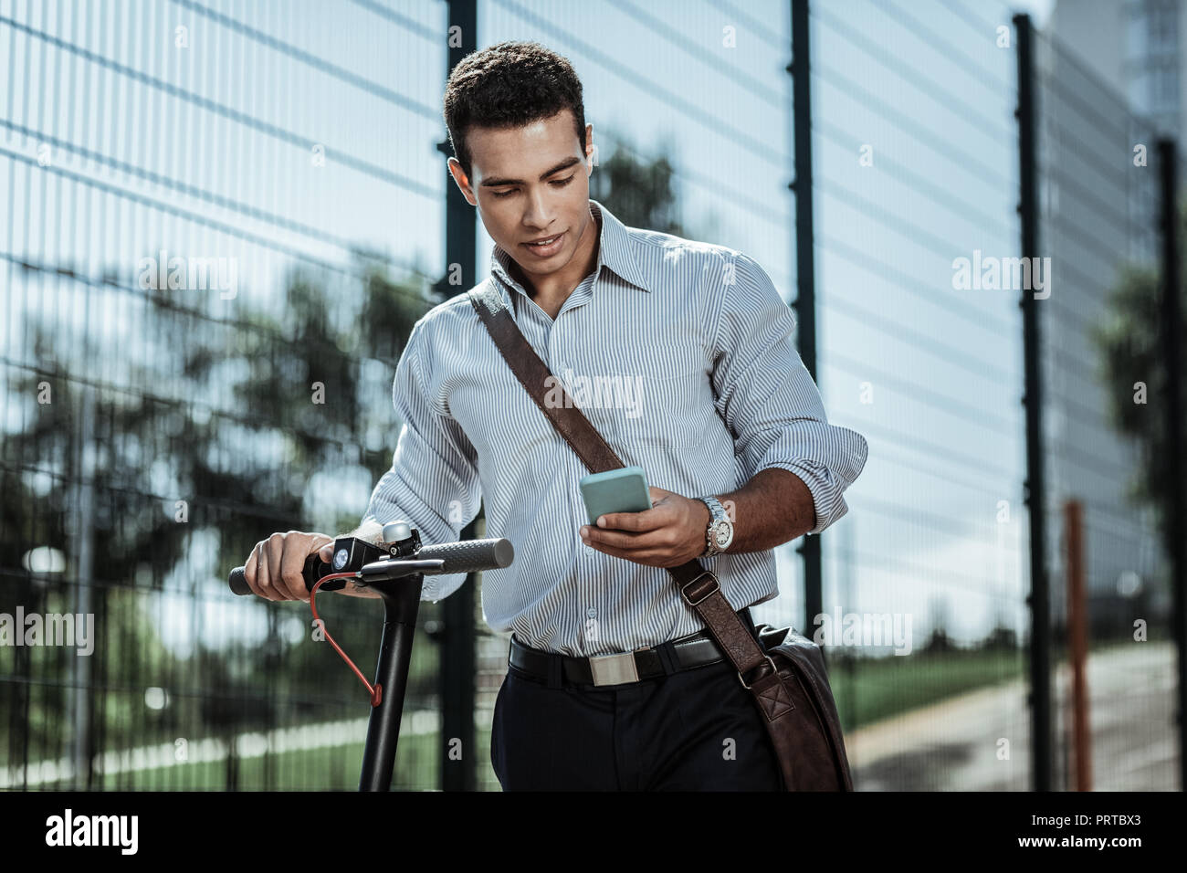 Focused serious guy starting his electric scooter Stock Photo