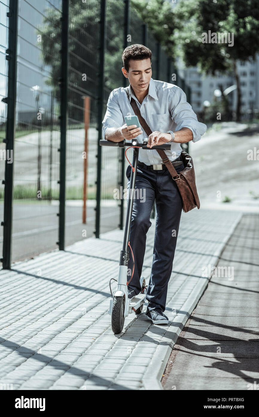 Concentrated focused guy tracking time to work Stock Photo