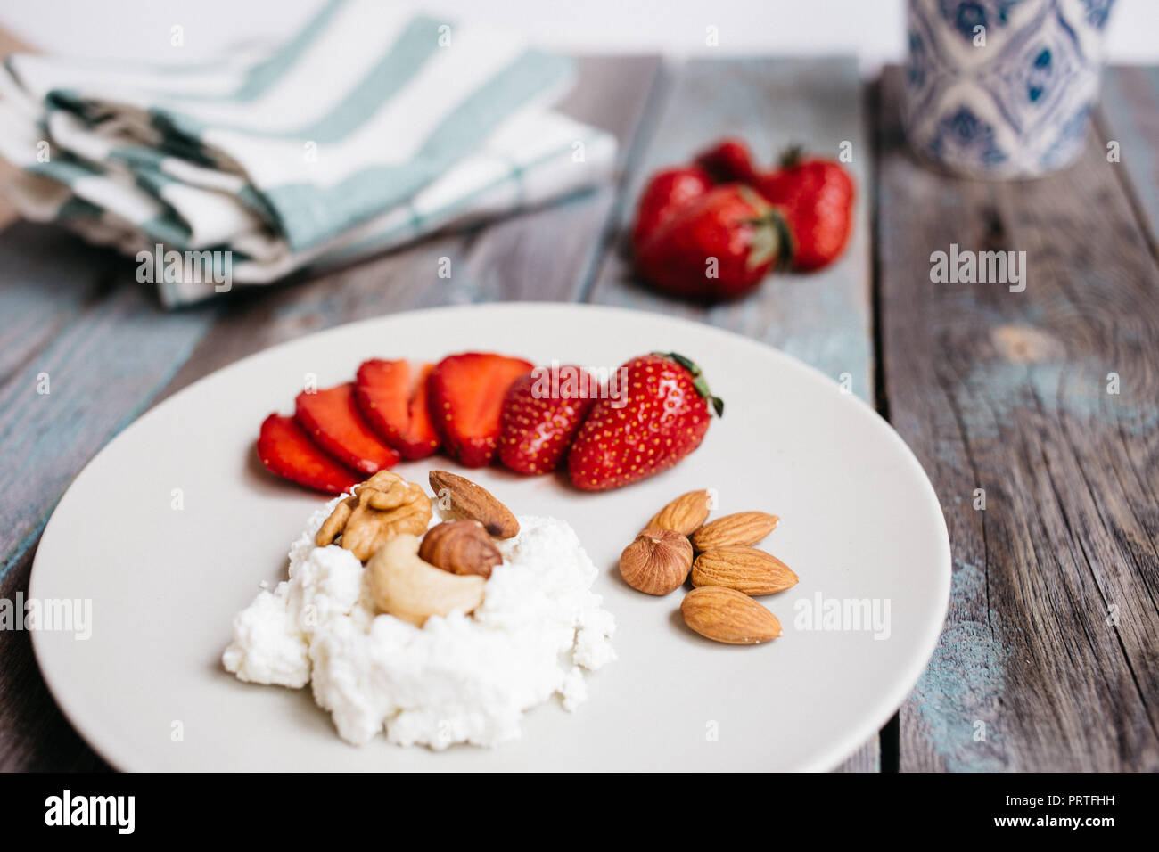 A Plate With Cottage Cheese Strawberries And Nuts A Cup Of