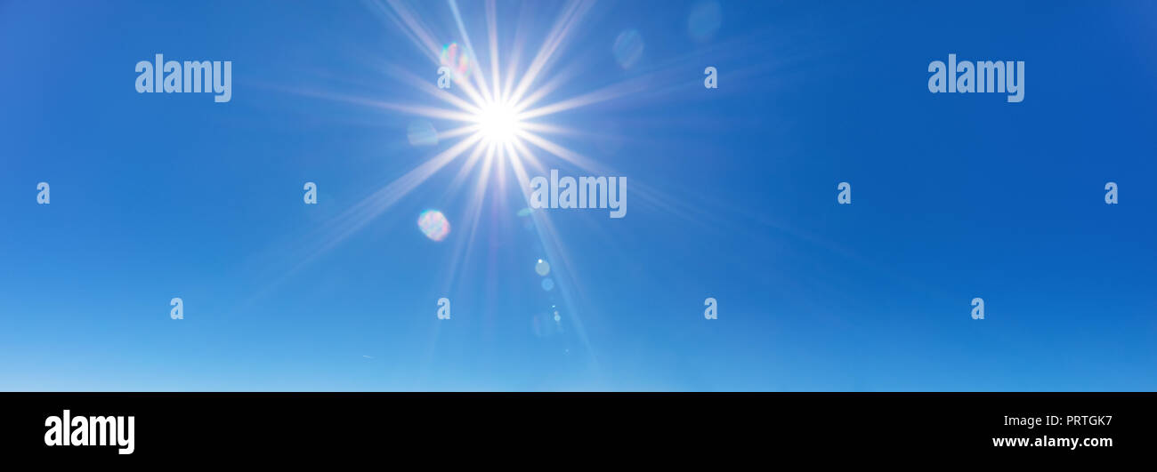 sky background with sun beams on bright blue sky Stock Photo