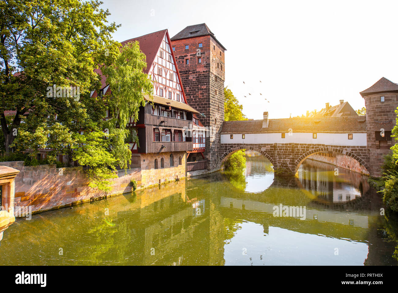 Beautiful landscape view on the riverside with old tower and house in Nurnberg during the sunrise, Germany Stock Photo