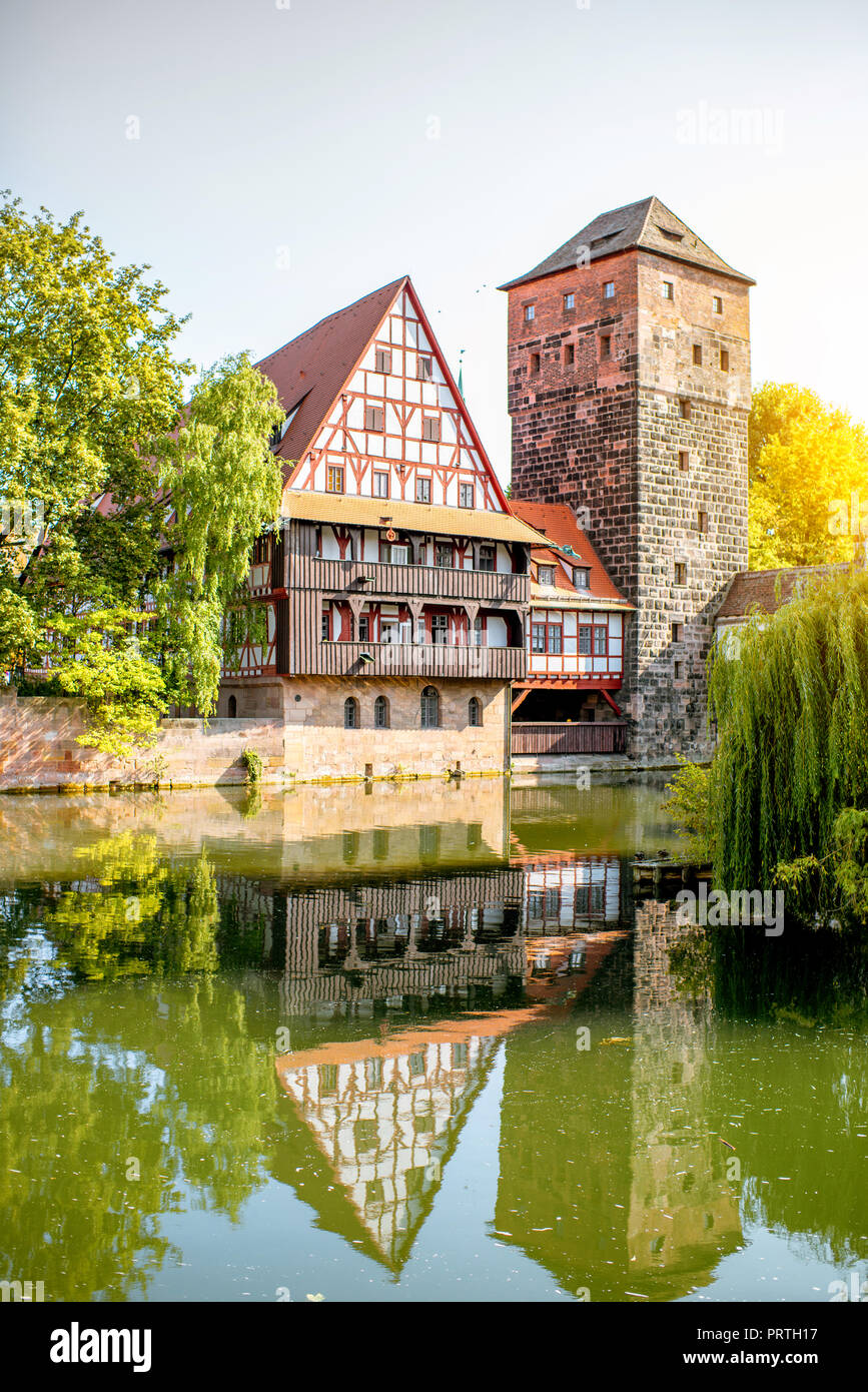 Beautiful landscape view on the riverside with old tower and house in Nurnberg during the sunrise, Germany Stock Photo