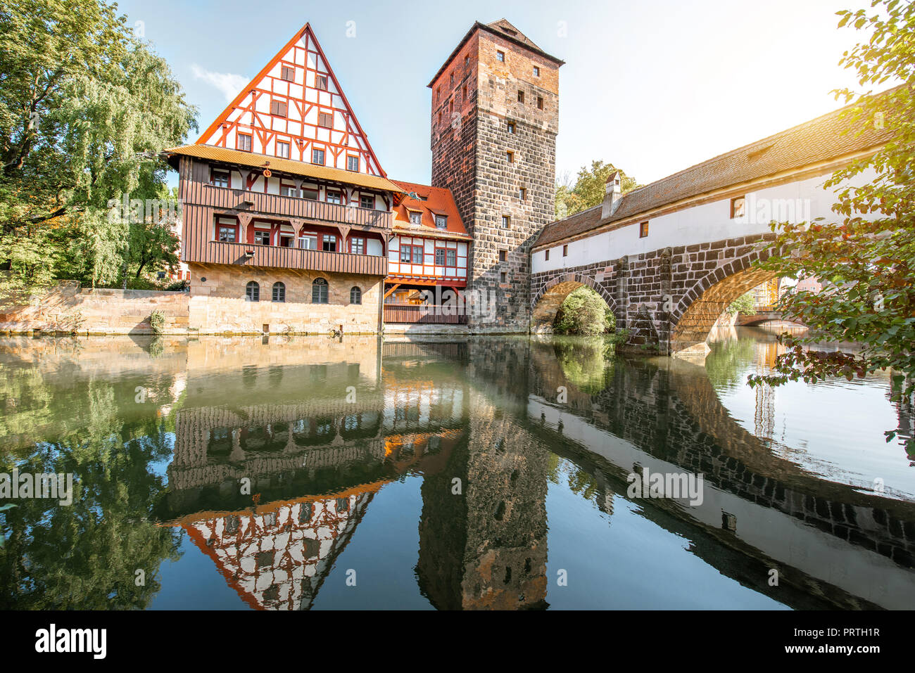 Beautiful landscape view on the riverside with old tower and house with reflection in Nurnberg during the sunrise, Germany Stock Photo