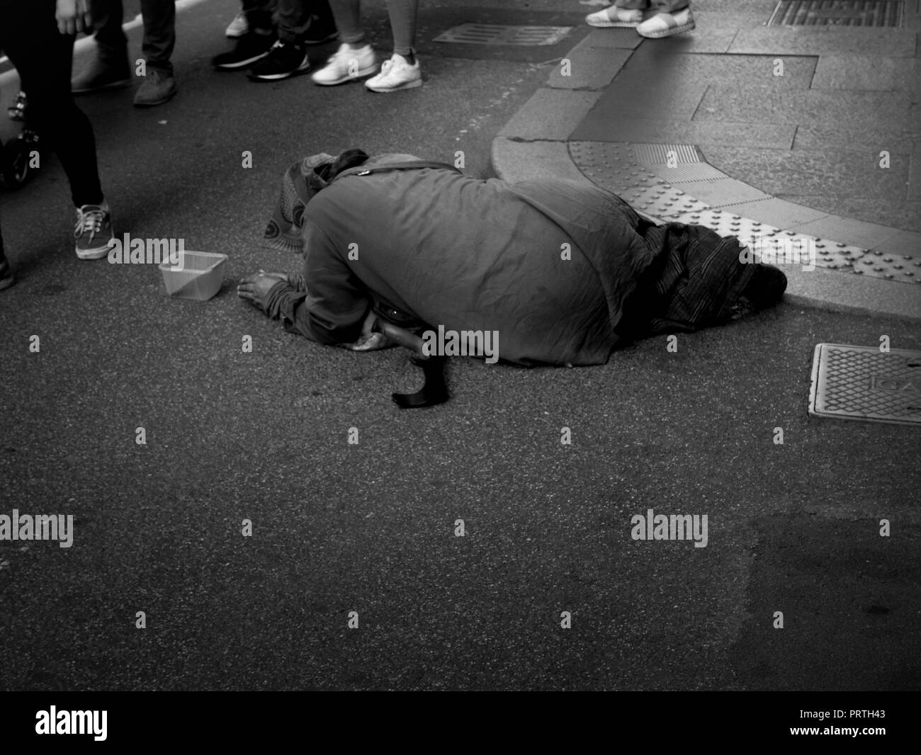 beggar lying on the ground to give alms Stock Photo