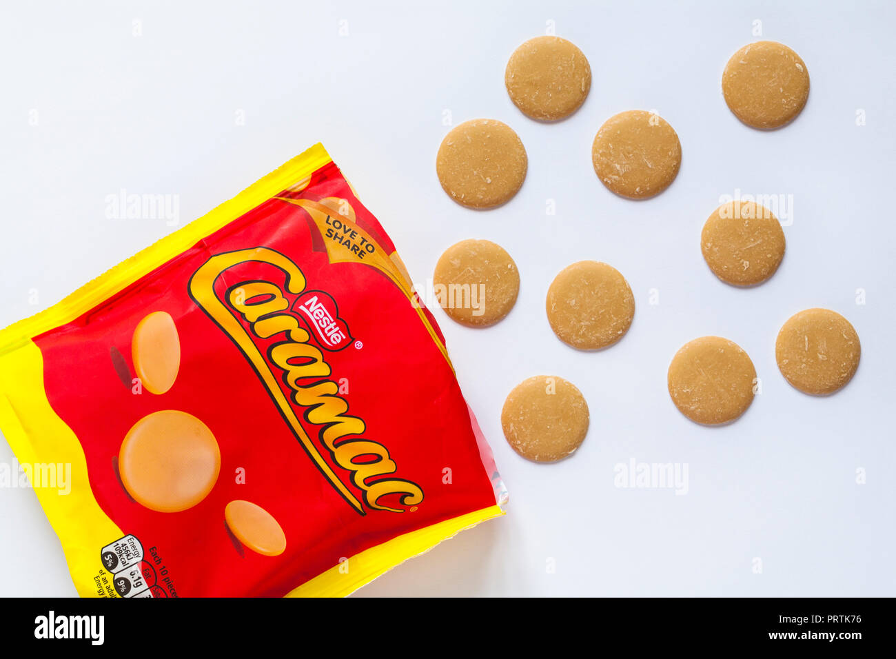 Bag of Nestle Caramac opened with contents spilled spilt set on white background - caramel flavour pieces Stock Photo