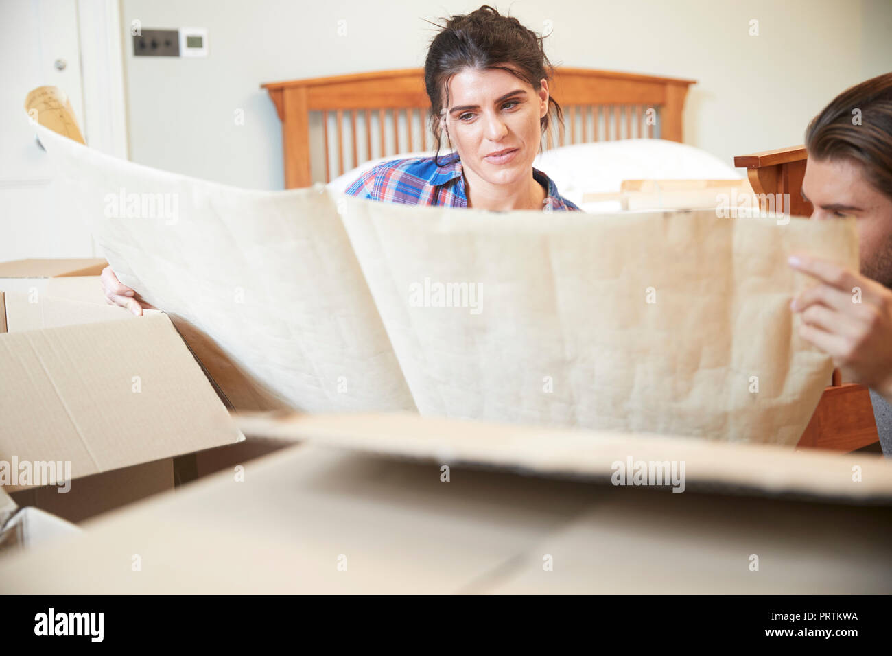 Couple reading blueprint layout in new home Stock Photo