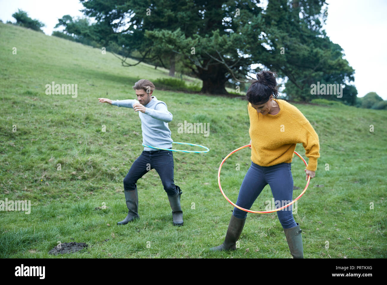 Couple hula hooping in field Stock Photo