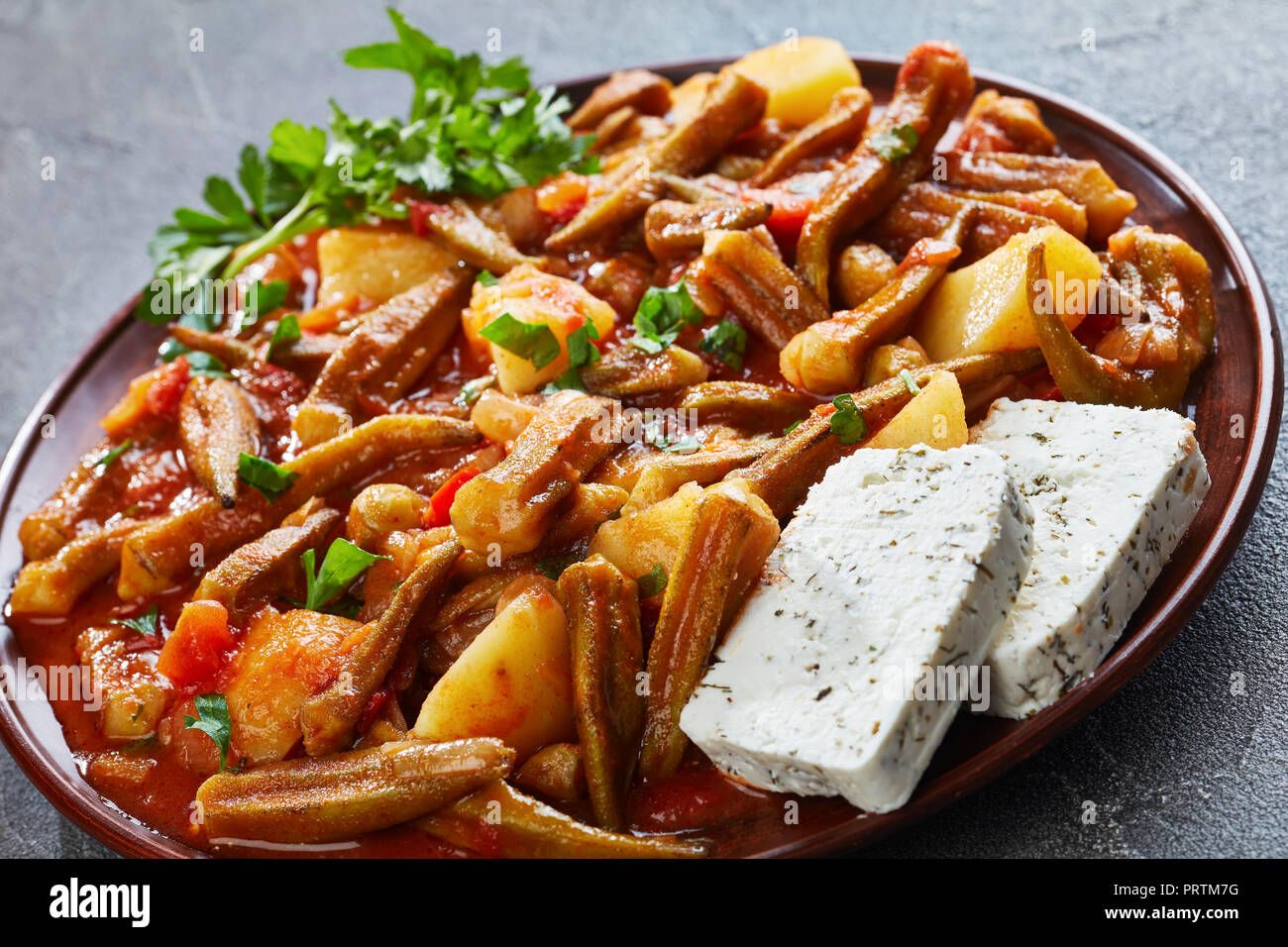 okra stewed with tomatoes and potatoes, served with feta cheese slices