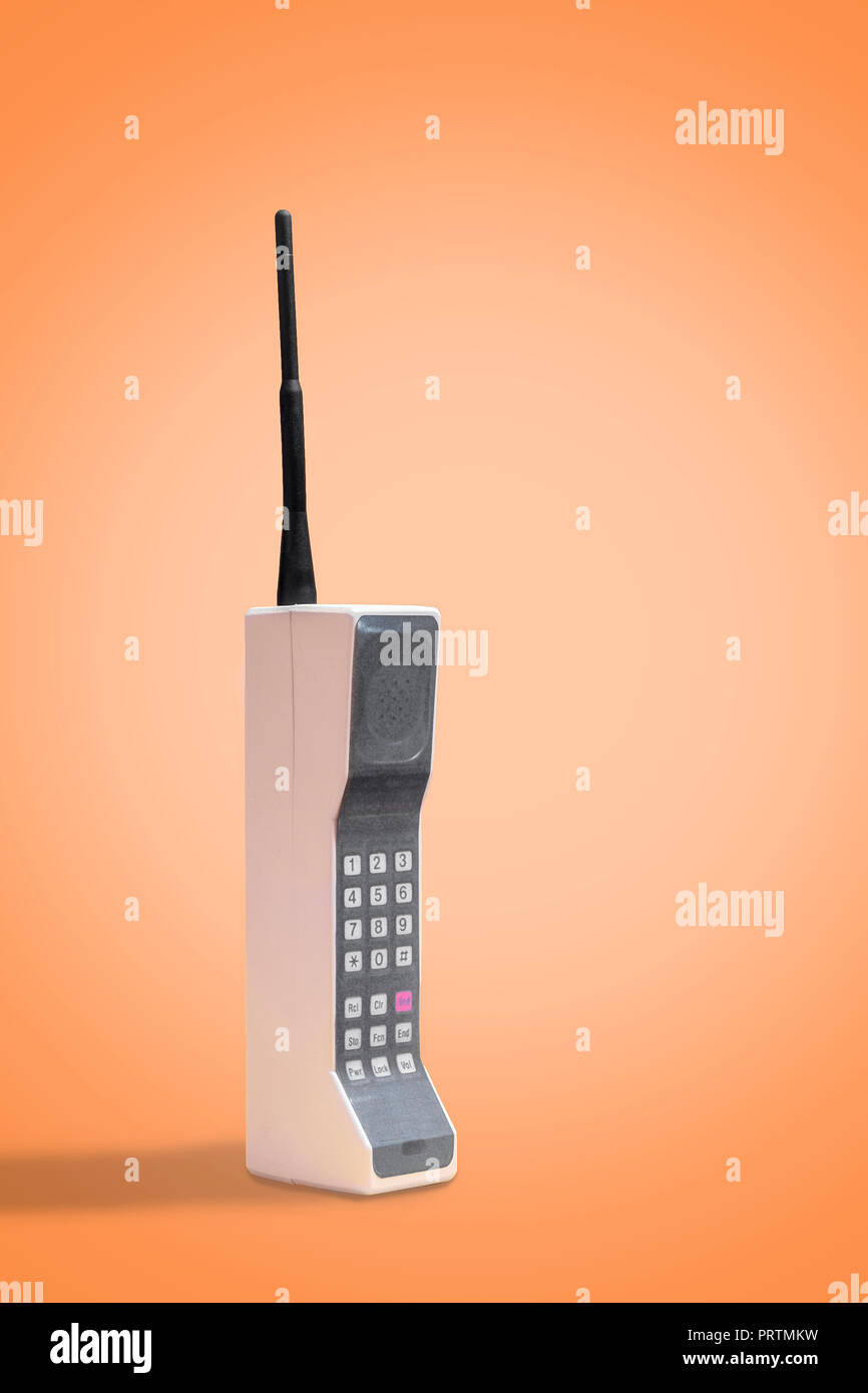 retro mobile cell phone on a vintage orange background with space for copy and text Stock Photo