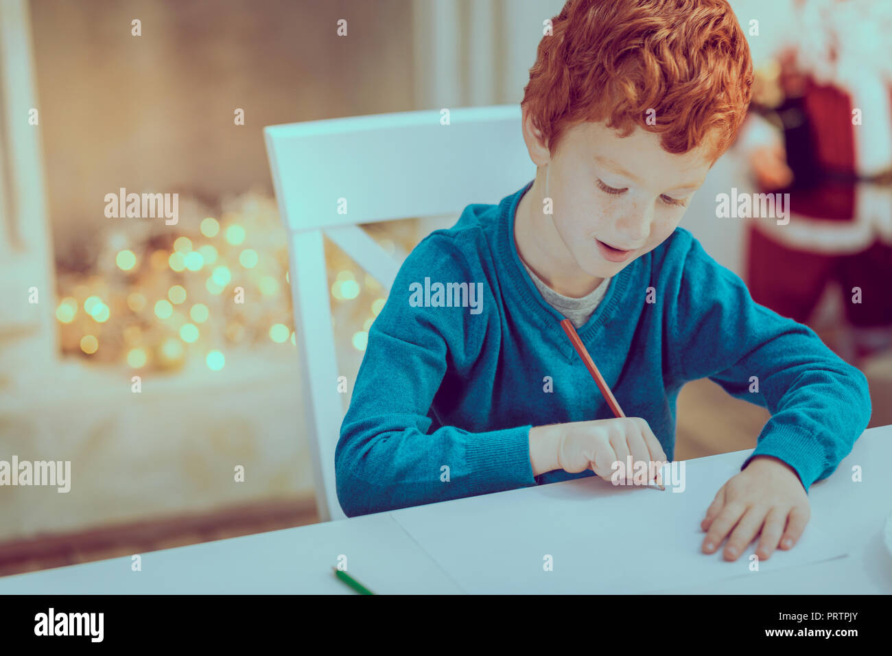Attentive kid drawing picture for his mom Stock Photo
