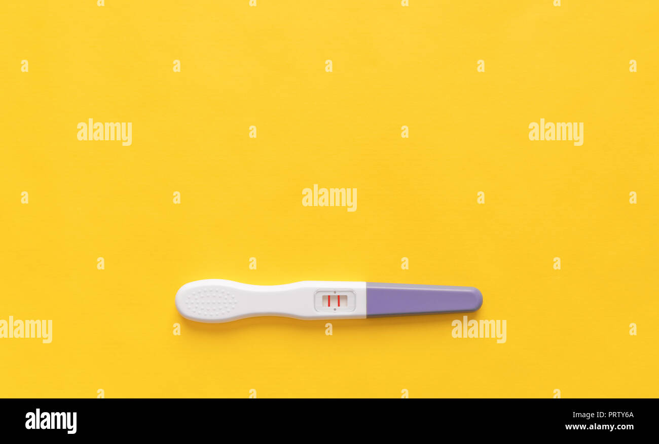 Pregnancy test on a yellow background. Close-up. Stock Photo