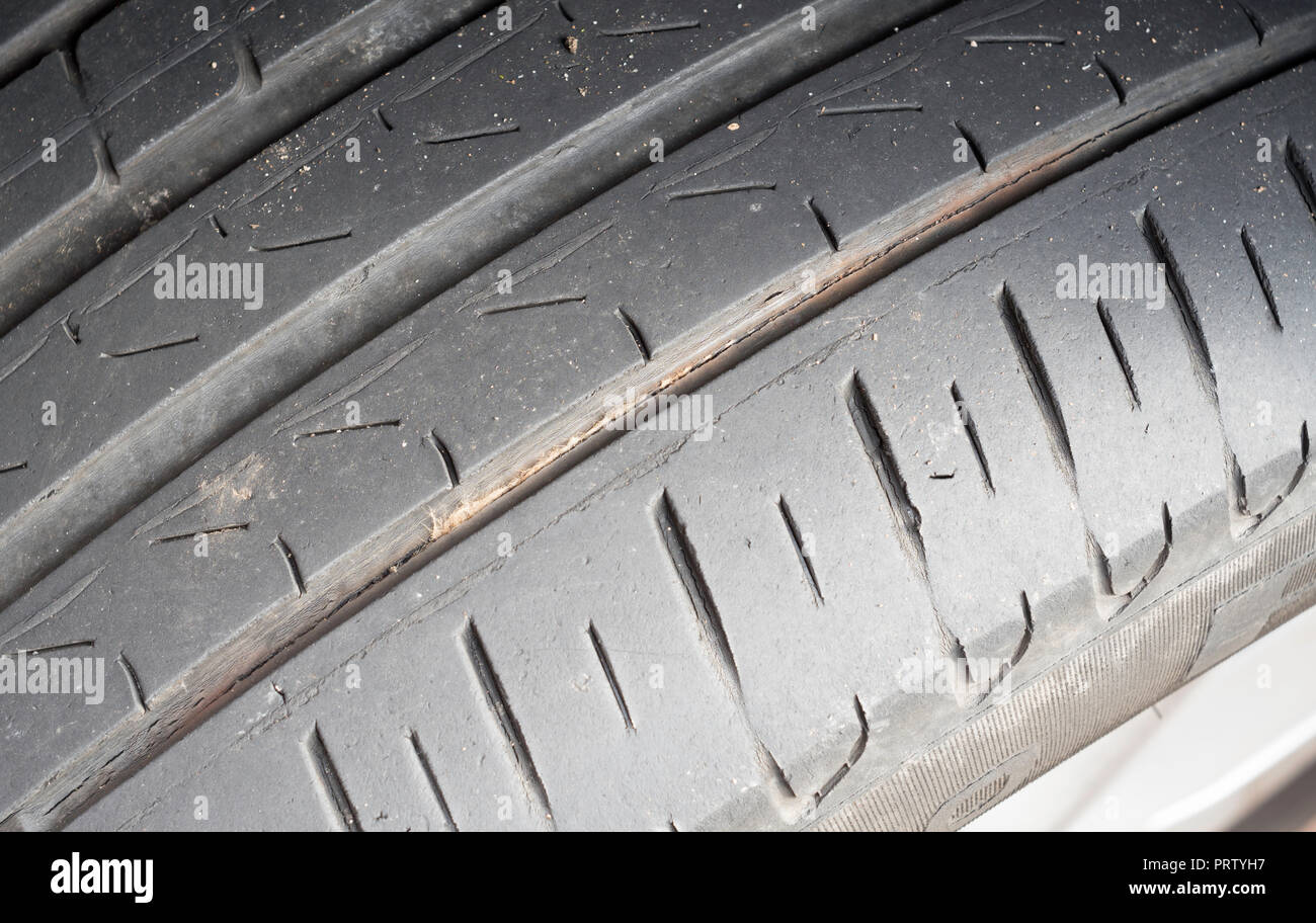 Car tyre with circumferential split or crack between the treads. Stock Photo