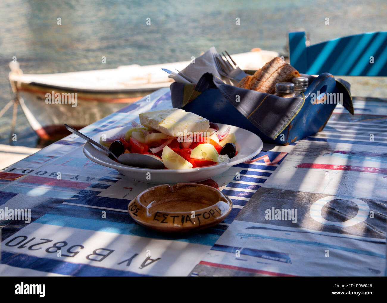 A light lunch of a Greek salad and bread beside the harbour on a Greek island Stock Photo