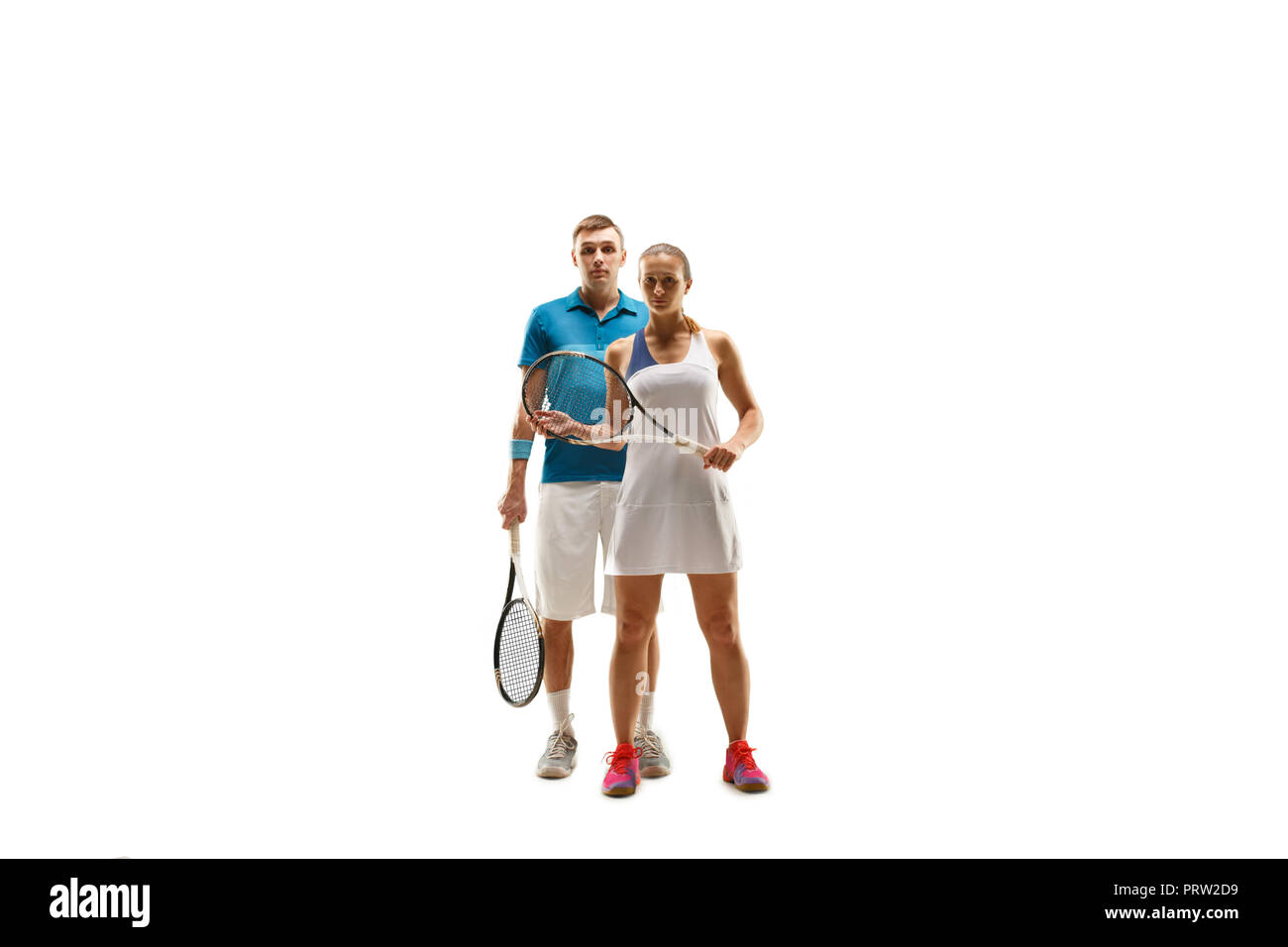 The caucasian couple of male and female tennis players posing isolated on white background