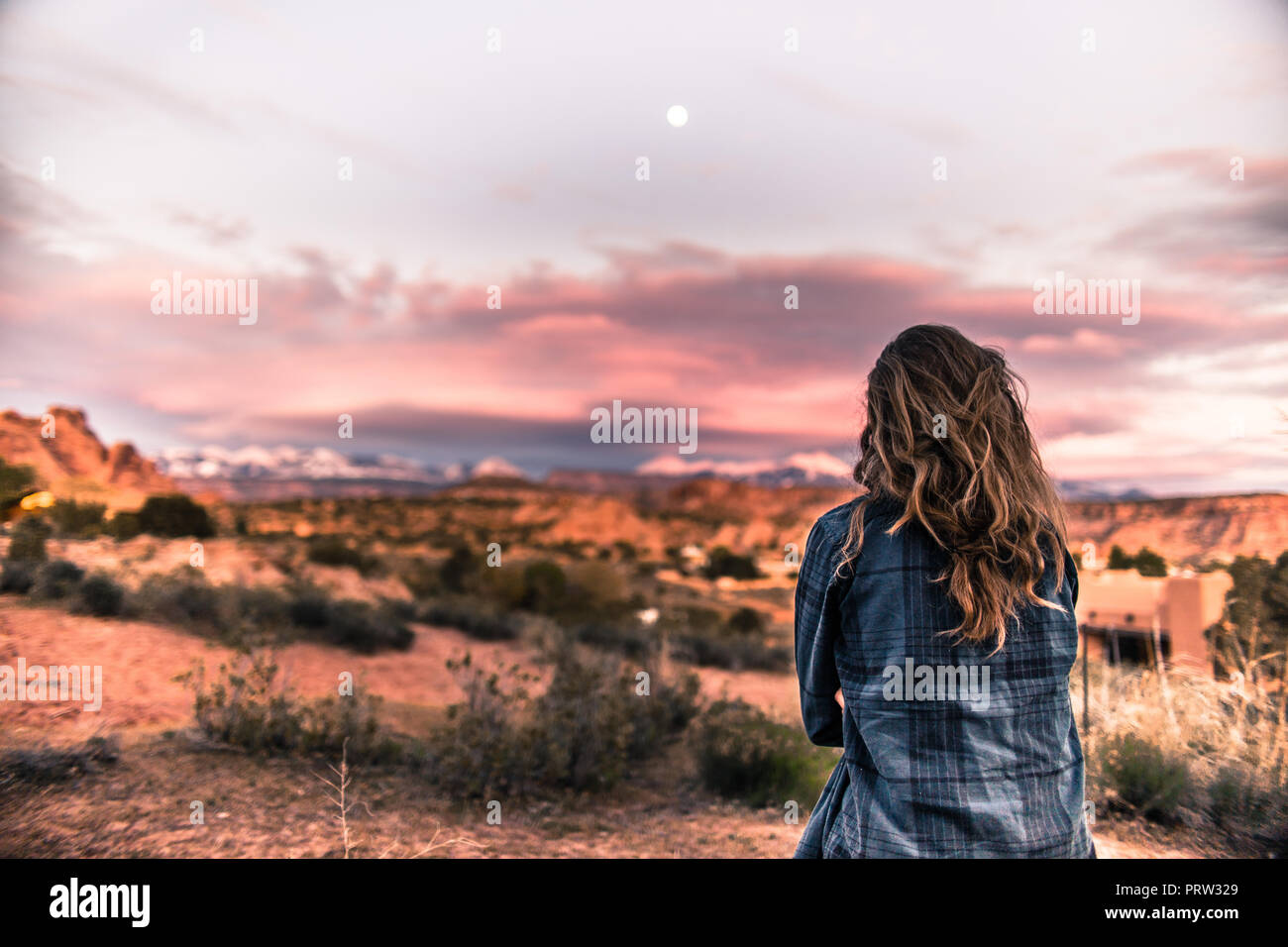 Woman looking at sunset in the desert, Moab, Utah Stock Photo