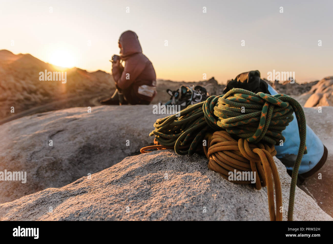 Rock climber on summit at sunset, Joshua Tree, California, USA Stock Photo