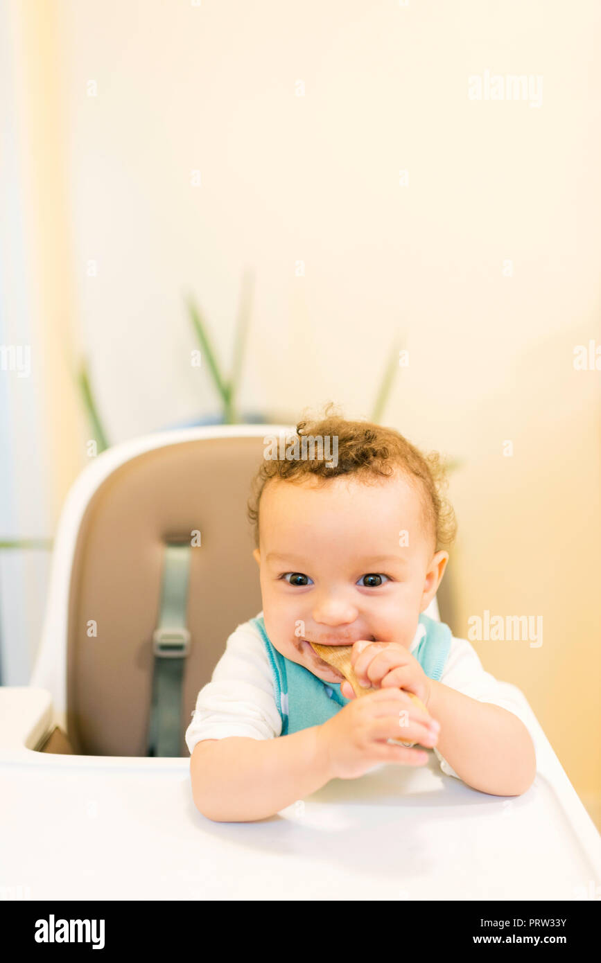 Smiling baby boy sitting in highchair Stock Photo