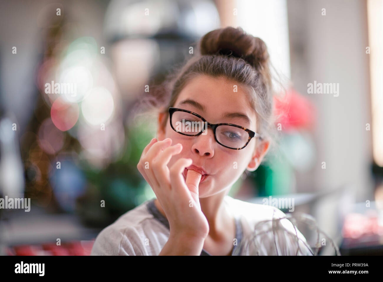 Girl licking christmas cookie dough from fingers in kitchen Stock Photo