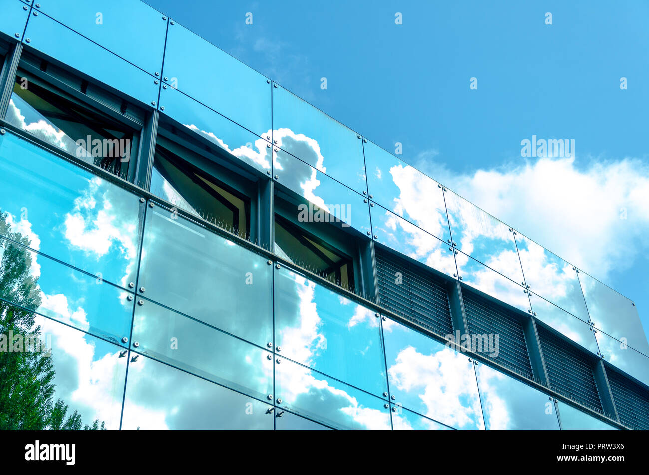 glass facade modern architecture mirroring clouds Stock Photo