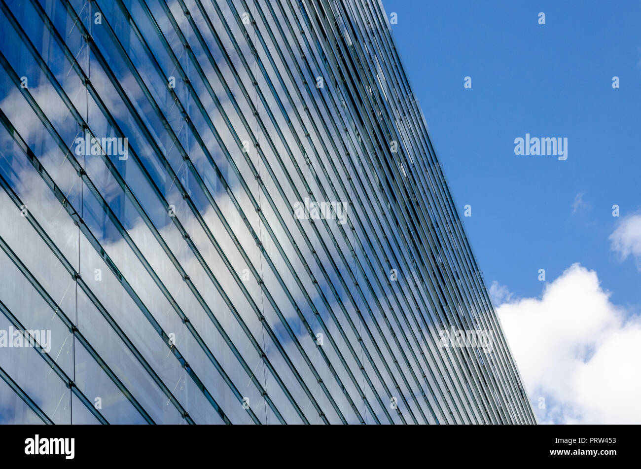 bright glass architecture facade mirroring some clouds Stock Photo