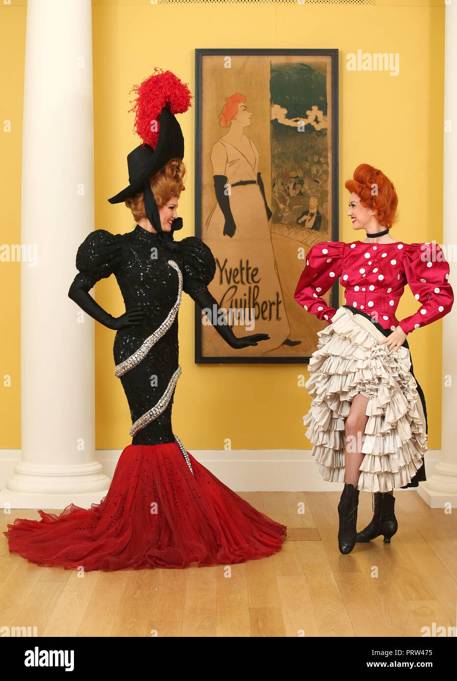 Mathilde Tutiaux (left) and Lucy Monaghan, can-can dancers from the Moulin Rouge in Paris, perform alongside a lithograph poster for Yvette Guilbert (1894) at opening of the new exhibition 'Pin-Ups: Toulouse-Lautrec and the Art of Celebrity' at the Royal Scottish Academy in Edinburgh. Stock Photo