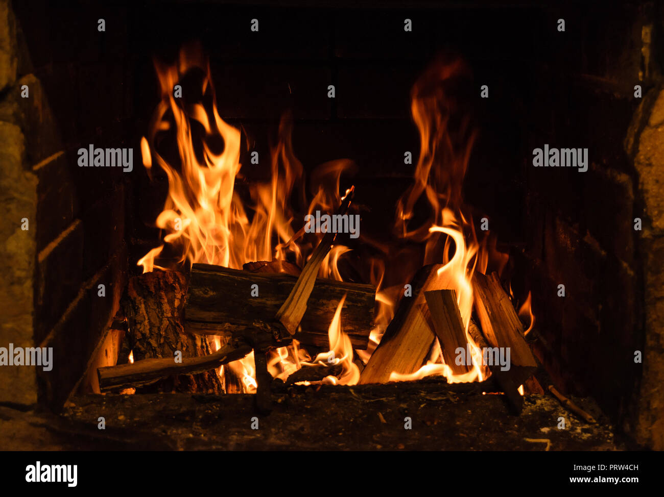 Burning woods in old fireplace. Traditional wood fired oven. Stock Photo