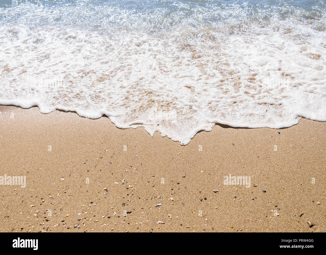 Wave on sandy beach background. Summer time. Stock Photo