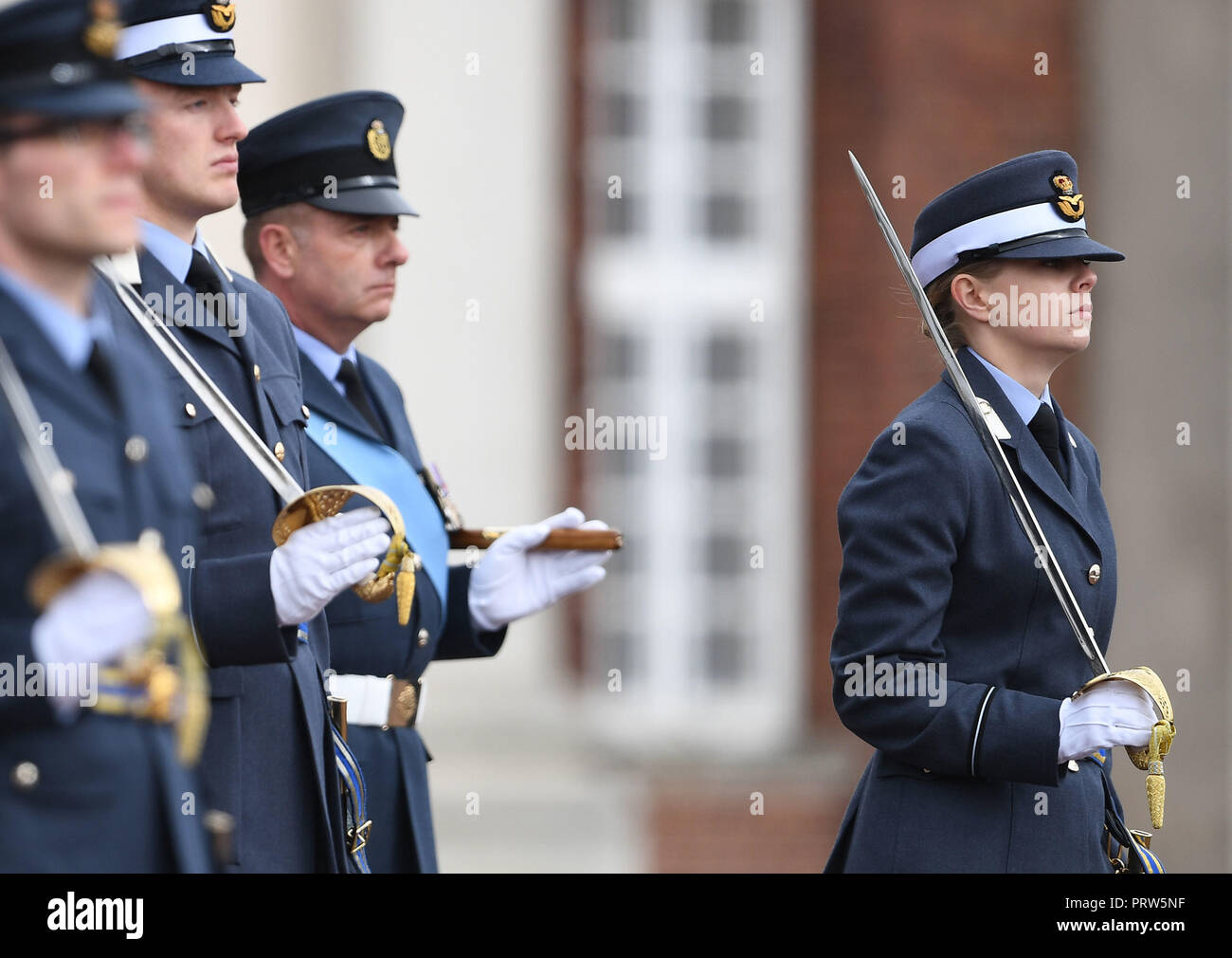 Flight Sergeant Philip Holt (third left) looks on as his daughter Officer Cadet Holly Holt 'passes out' as the RAF held its first ever joint graduation ceremony for officers and non-commissioned airmen and airwomen at RAF College Cranwell in Lincolnshire on Thursday. Stock Photo