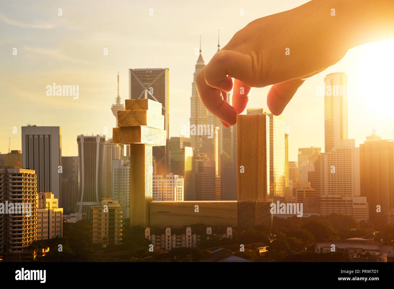 Unknown hand build a wooden blocks tower in downtown . Learning ,real