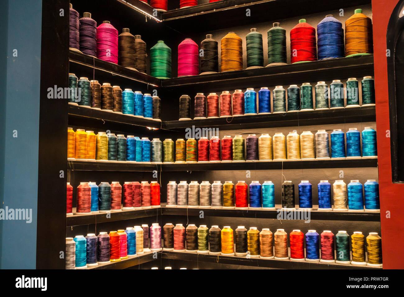 Spools of colorful threads on shelves Stock Photo