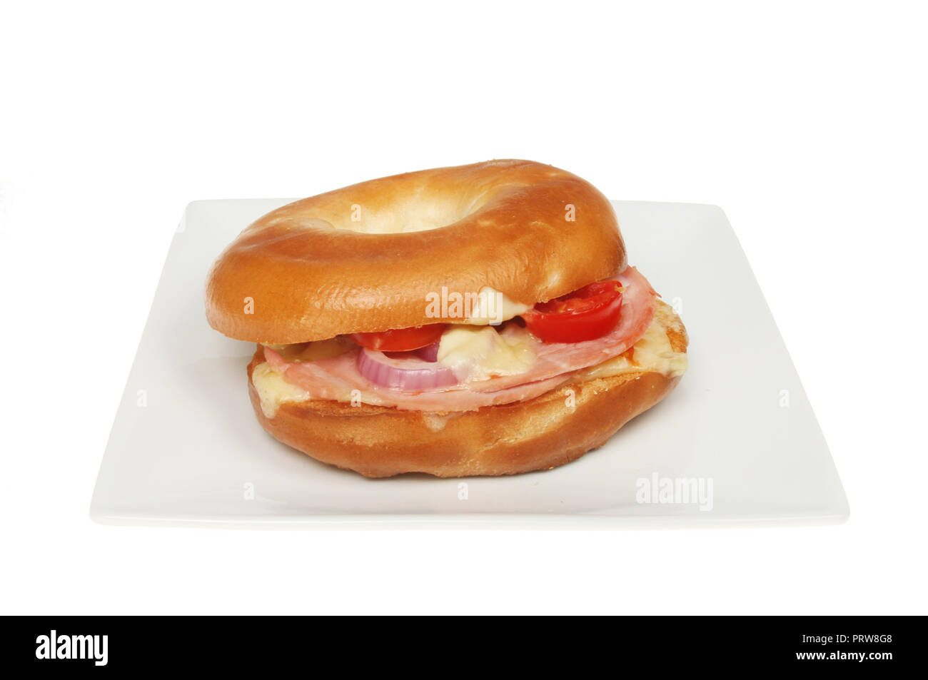 Toasted cheese, onion, tomato and ham bagel on a plate isolated against white Stock Photo