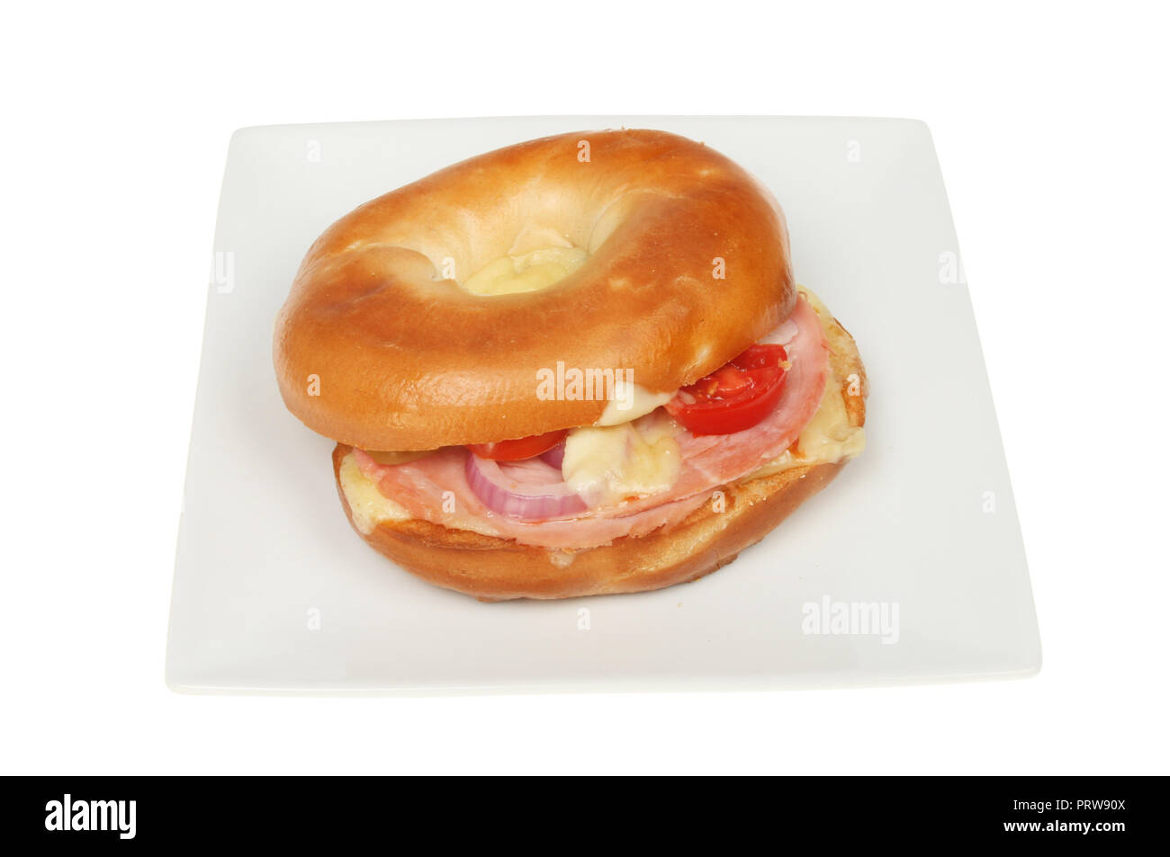 Toasted cheese, red onion, ham and tomato bagel on a plate isolated against white Stock Photo