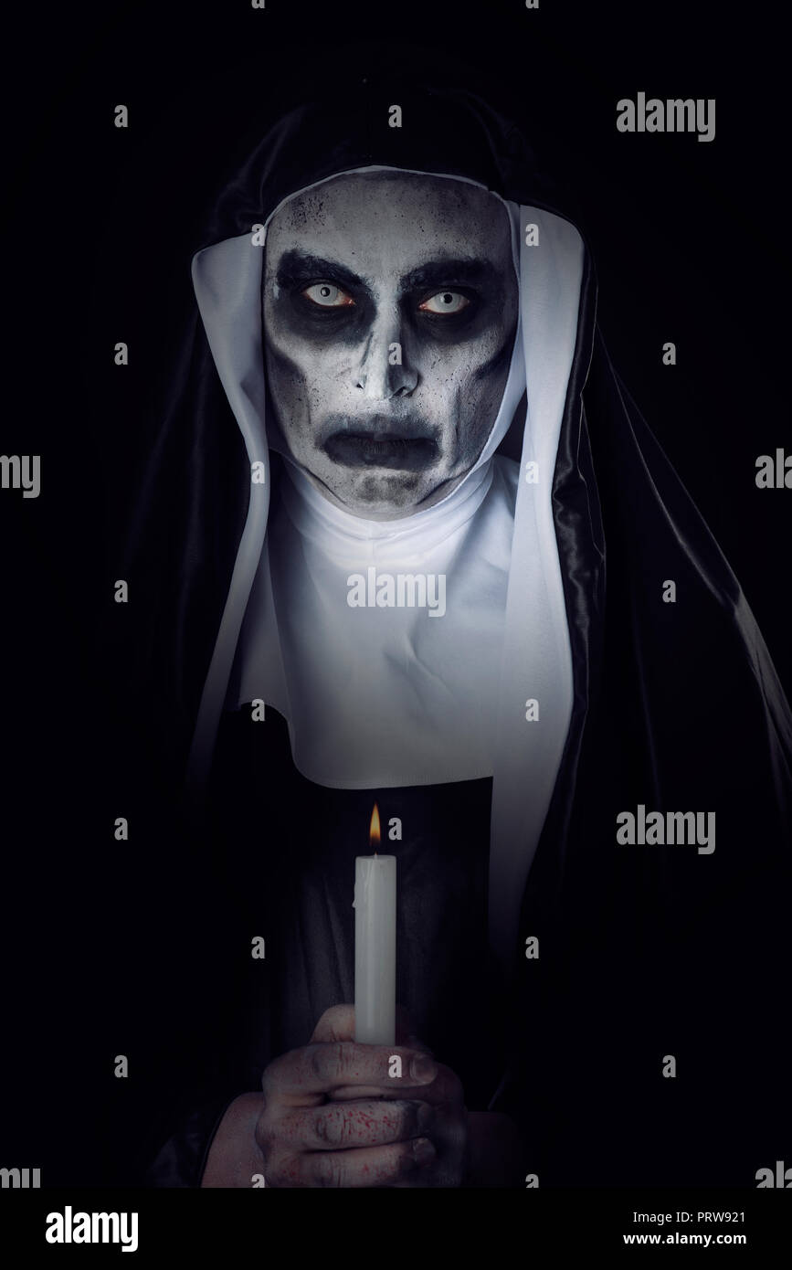 closeup of a frightening evil nun, wearing a typical black and white.