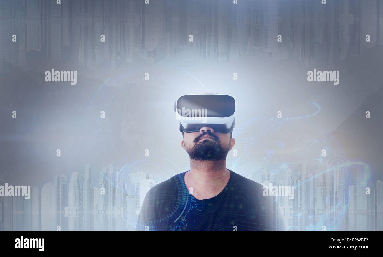 Young Guy in black t shirt looking through VR (Virtual Reality) glasses - Looking Up Stock Photo