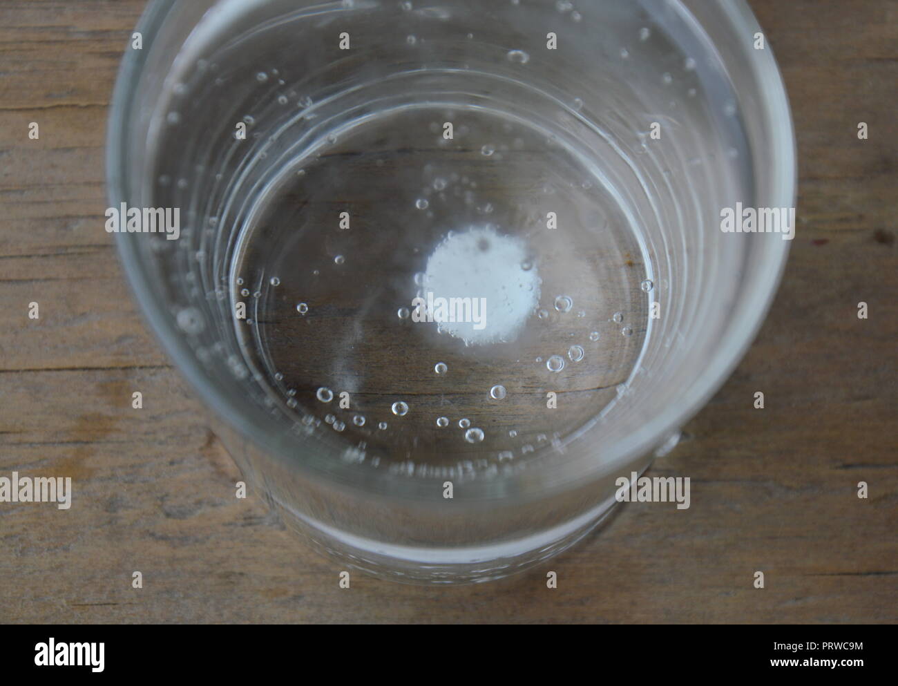 antacids in water glass on wooden table Stock Photo