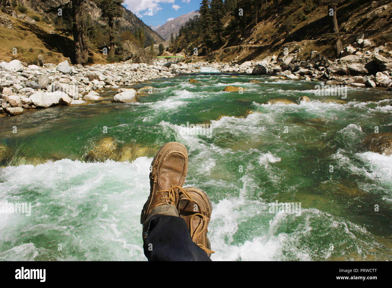 POV shot - traveller sitting on a river in beautiful valley of swat, Pakistan Stock Photo