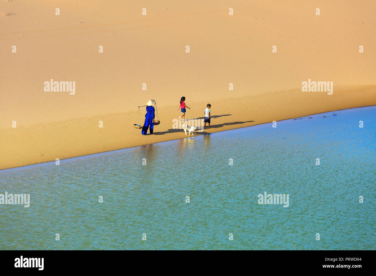 woman carries a bamboo frame on the shoulder and two children walking ...