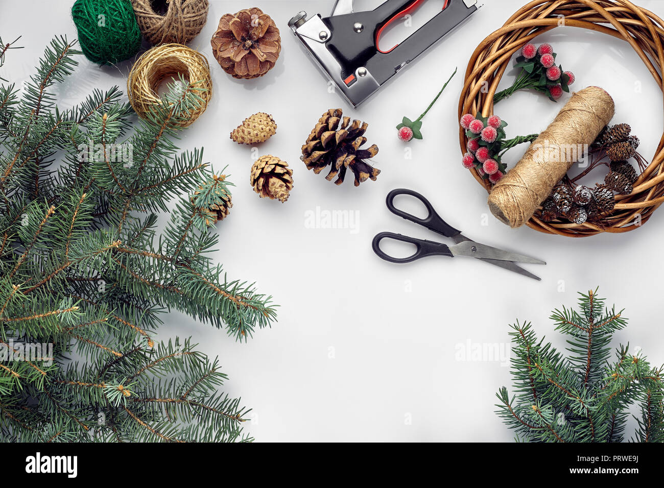 Beautiful Festive Handmade Wreath Base With Three Bumps Near It Threads And Twigs Blue Christmas Tree On The White Table Background Flat Lay Stock Photo Alamy