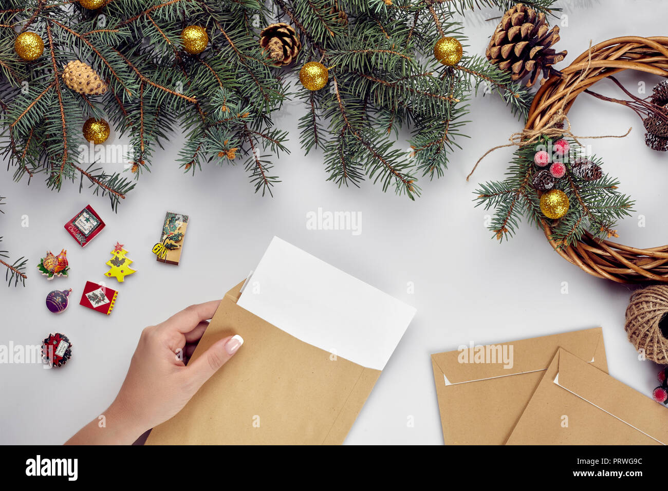 Christmas table with various items. Woman's hands putting a letter in