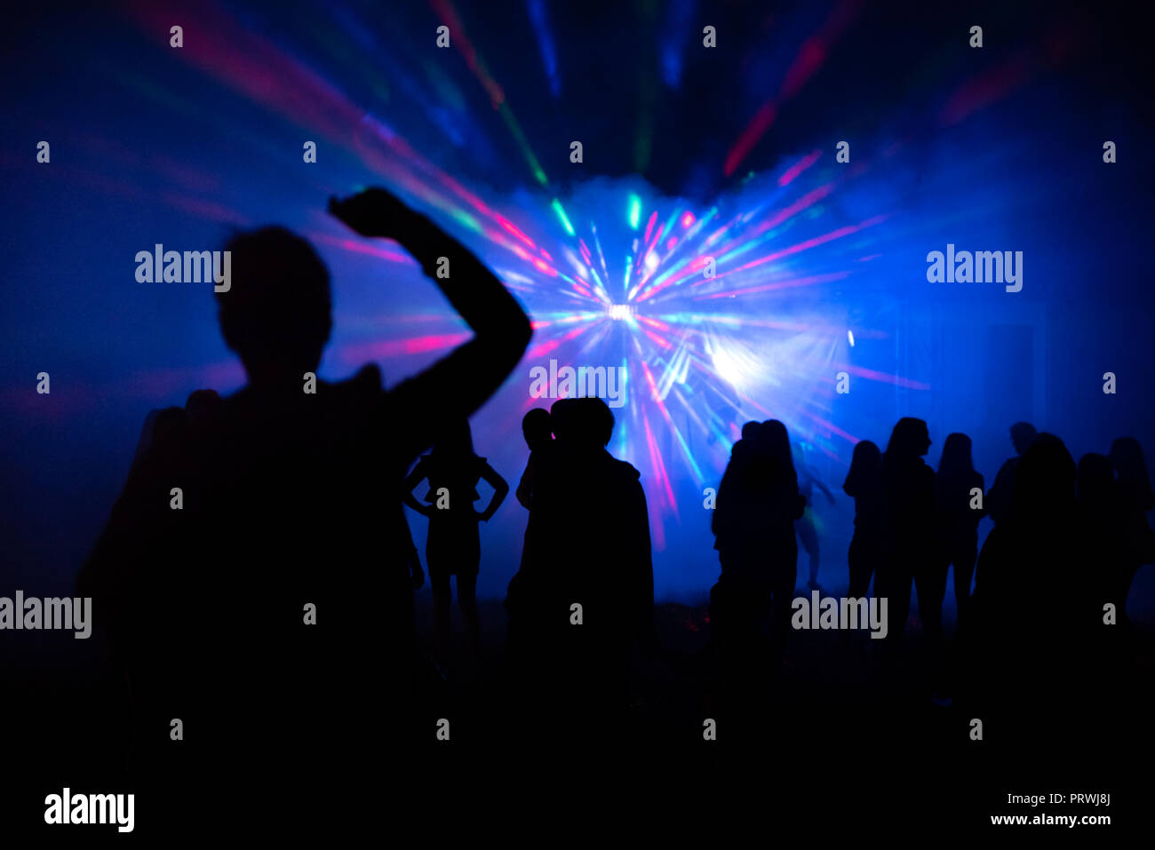 Abstract blurry background, silhouettes of people at open air party Stock Photo