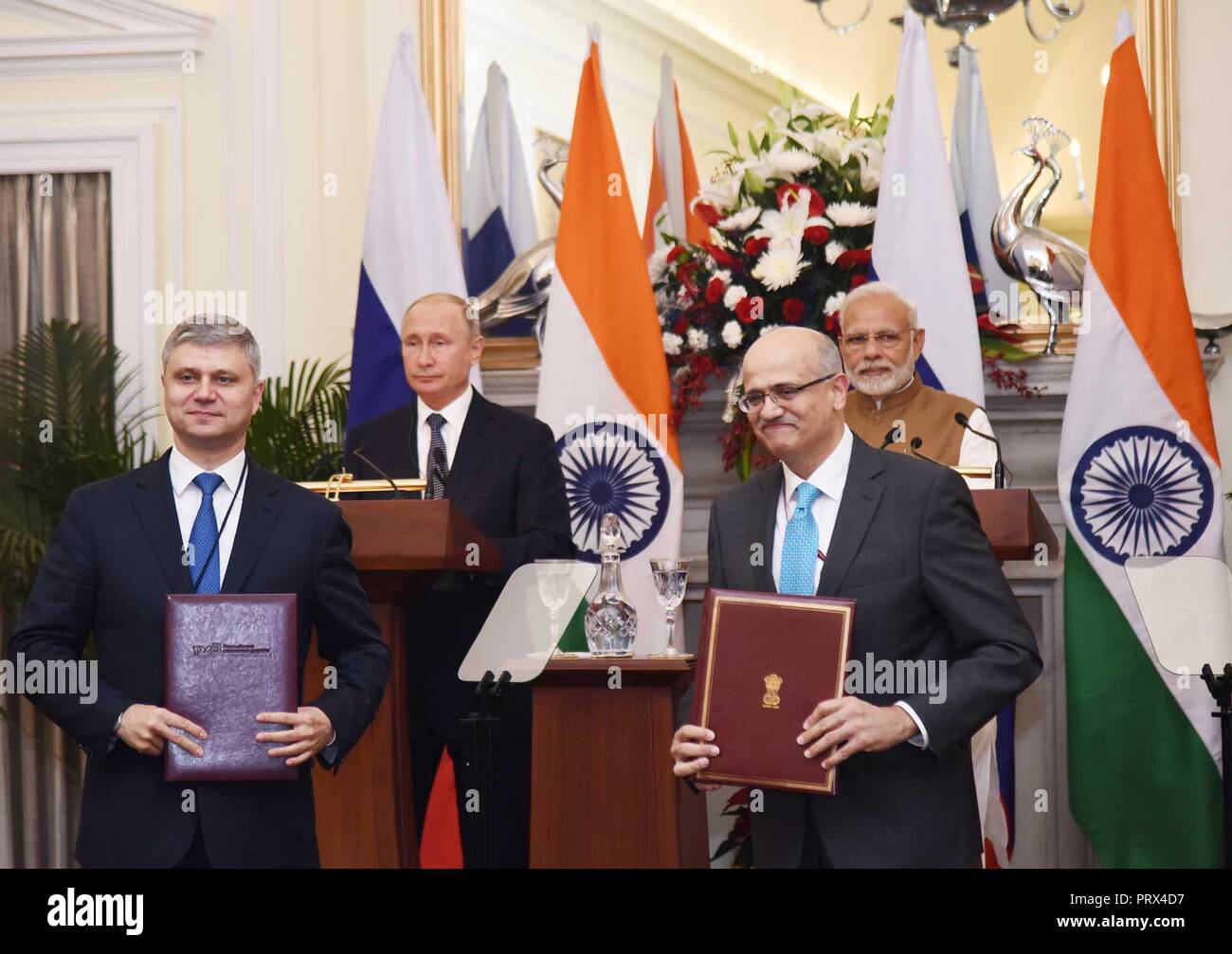 New Delhi, India. 5th Oct 2018. Russian Railways CEO Oleg Belozerov, left, and Indian Foreign Secretary Vijay Gokhale after exchanging agreements as Russian President Vladimir Putin, rear left, and Indian Prime Minister Narendra Modi, rear right, look on at Hyderabad House October 5, 2018 in New Delhi, India. Credit: Planetpix/Alamy Live News Stock Photo