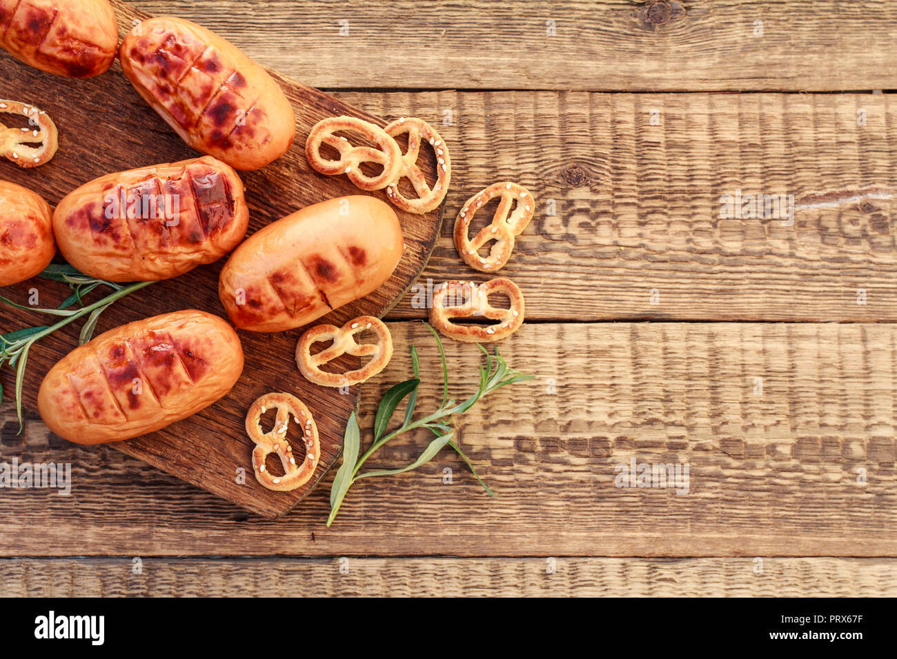 Fried sausages on wooden chopping board. BBQ, picnic Stock Photo