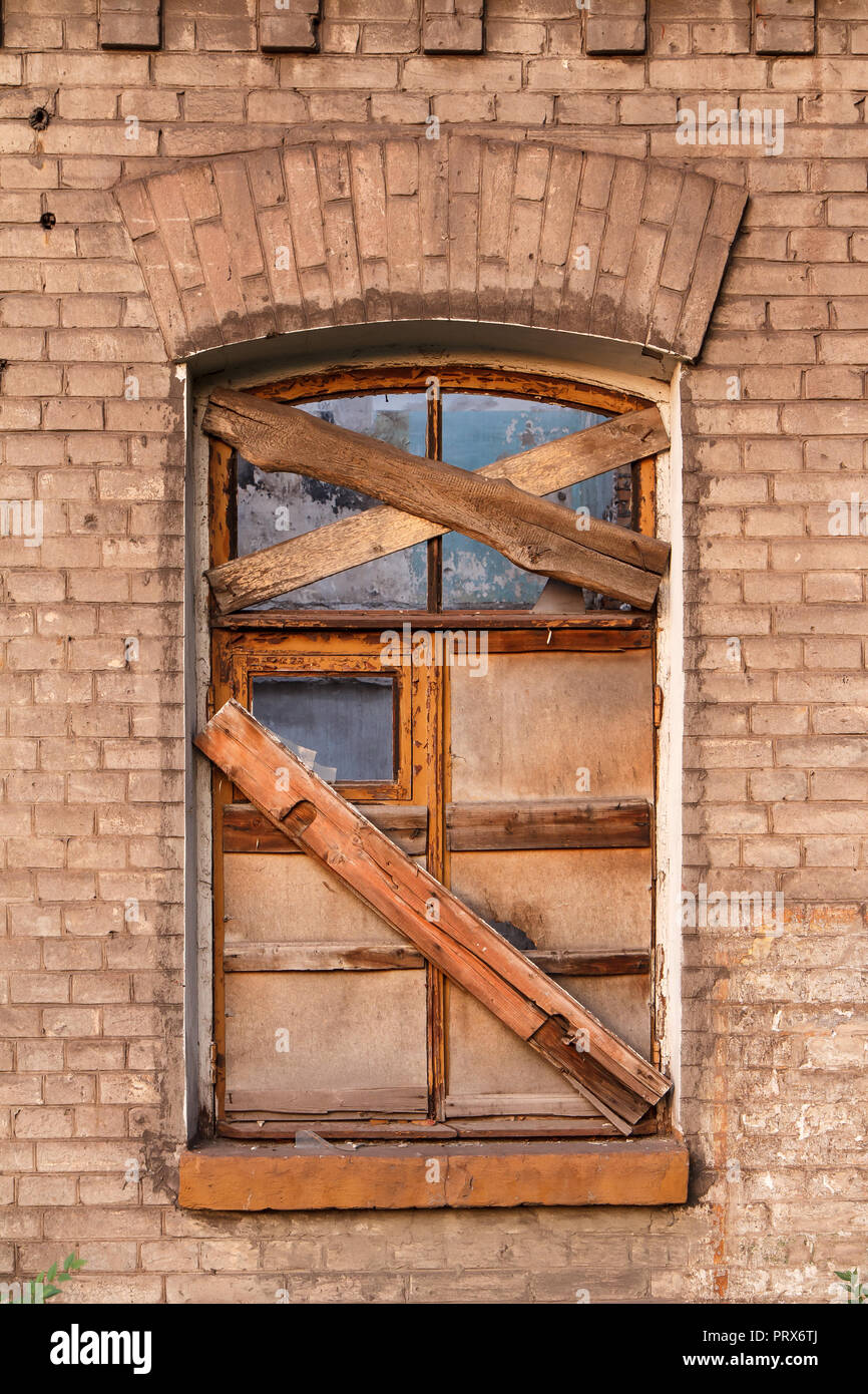 Window lined with wooden boards in old abandoned brick building Stock ...