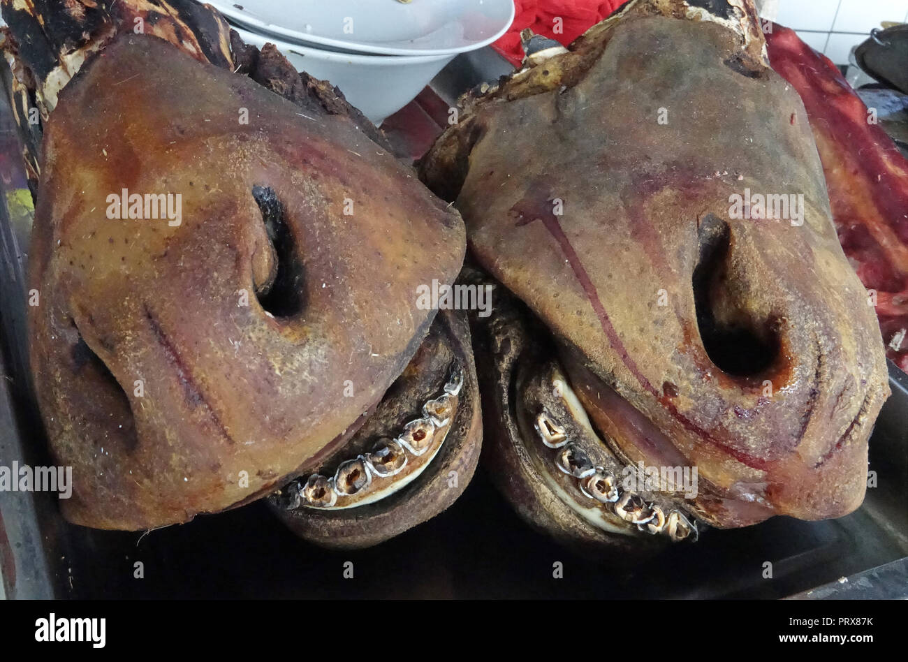 cattle head portions with nostrils and broken teeth for sale at meat stall at local public market Stock Photo