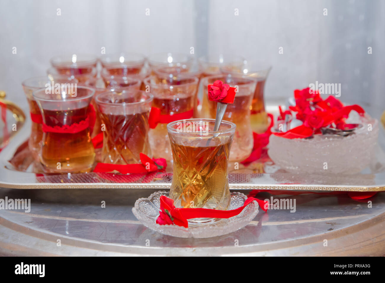 tea in eastern glass on the silver salver on the white tablecloth, Arabic, Turkish, Azerbaijani customs Stock Photo