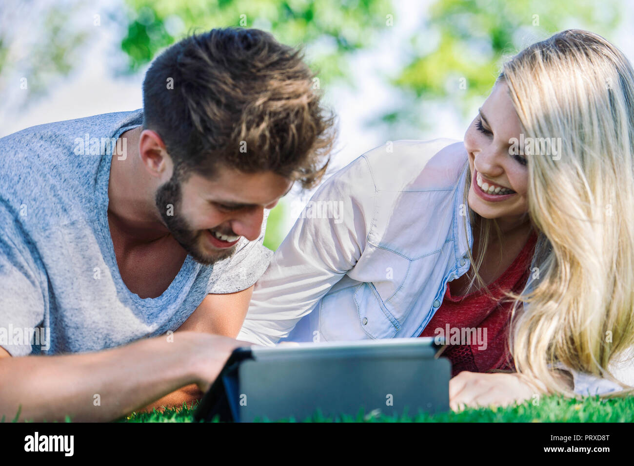 Couple using digital tablet in park Stock Photo